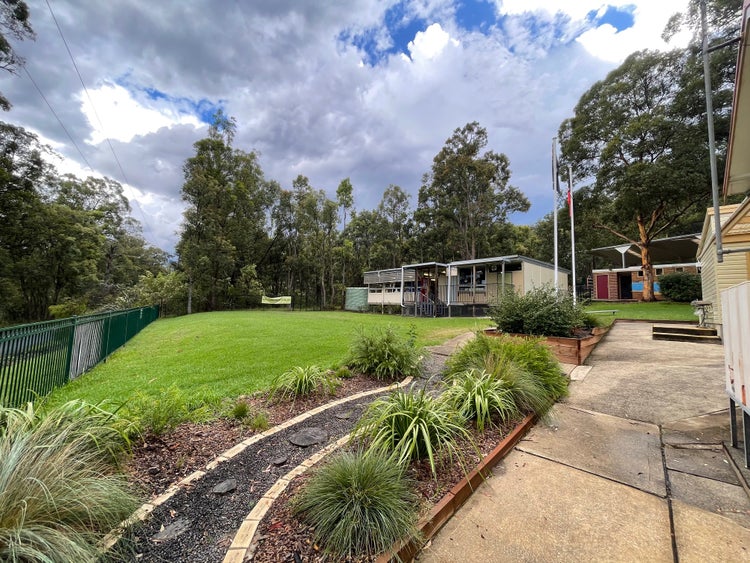 grass oval with classrooms in background