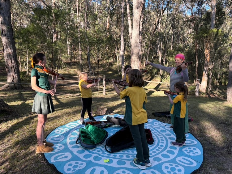students playing violin outside