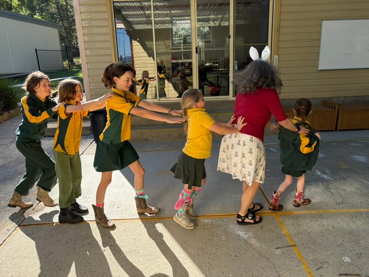 teacher and students in a congo line learning a dance