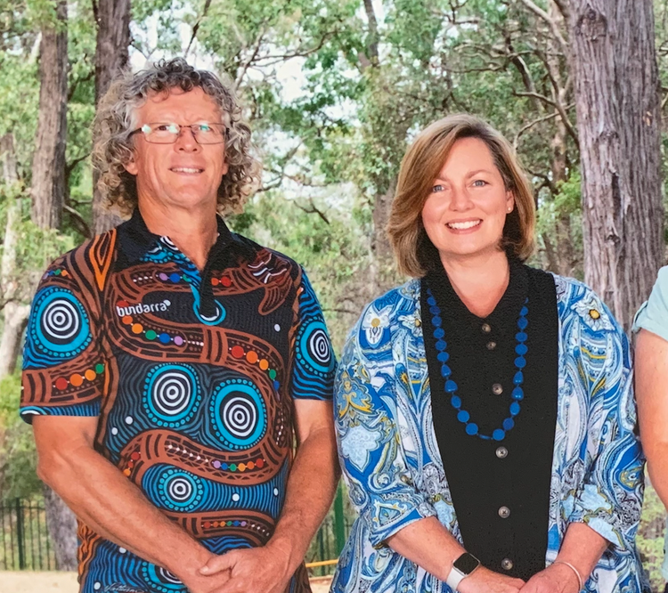 staff standing against a bush background