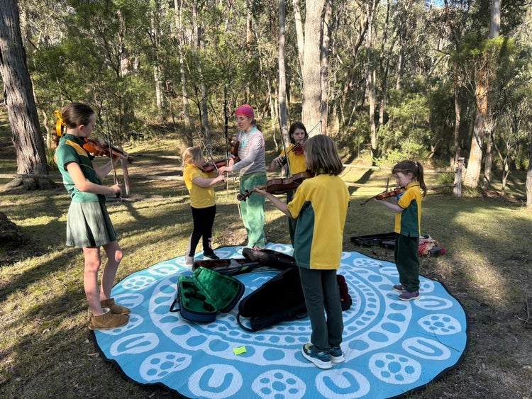 Students playing violins outside