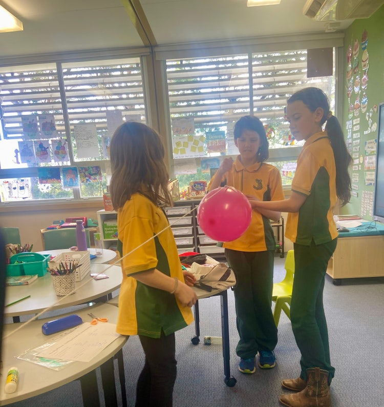students experimenting with force and direction with a balloon
