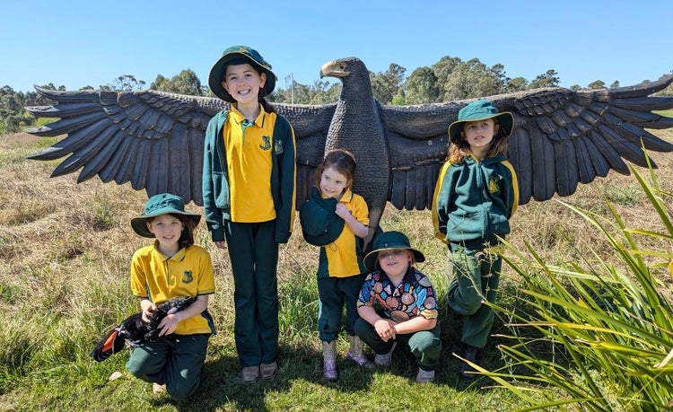 students outside with bird sculpture