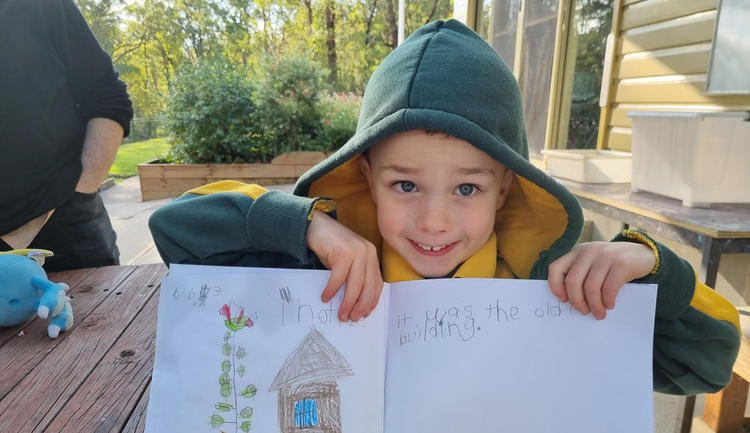 student holding up their work