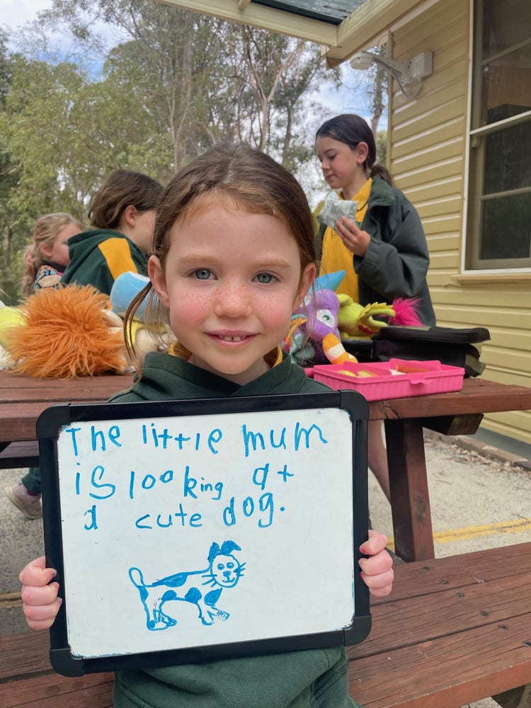 student holding a whiteboard with writing on t